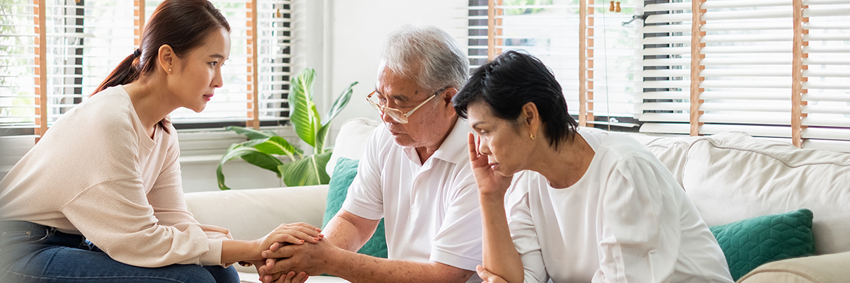 A distressed family of an older Asian man with his two adult children.