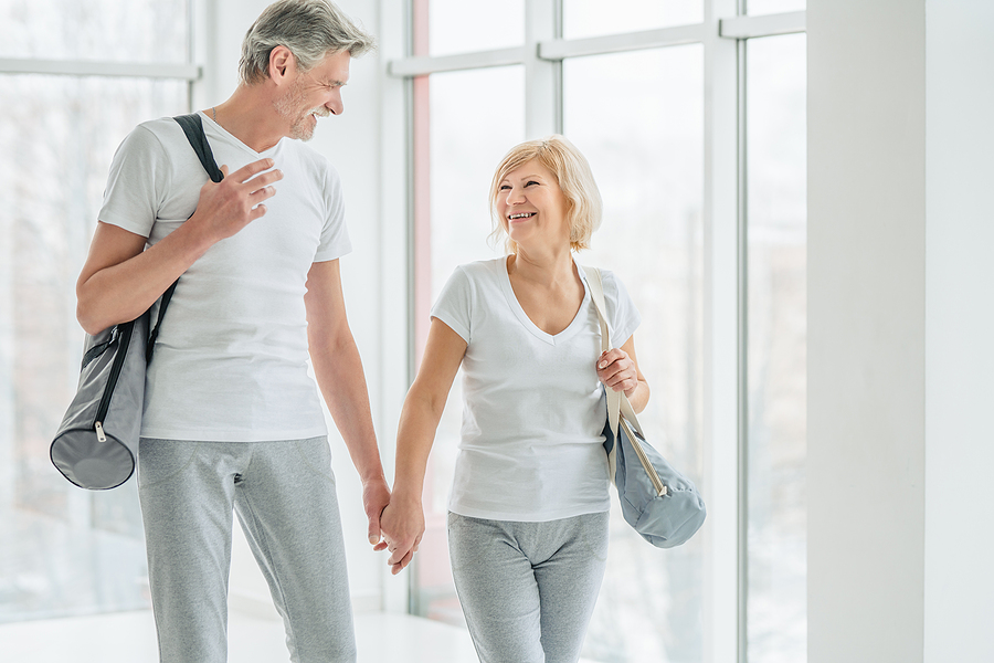 A senior couple walks into the gym together.