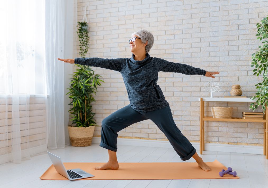 A senior woman exercises at home.