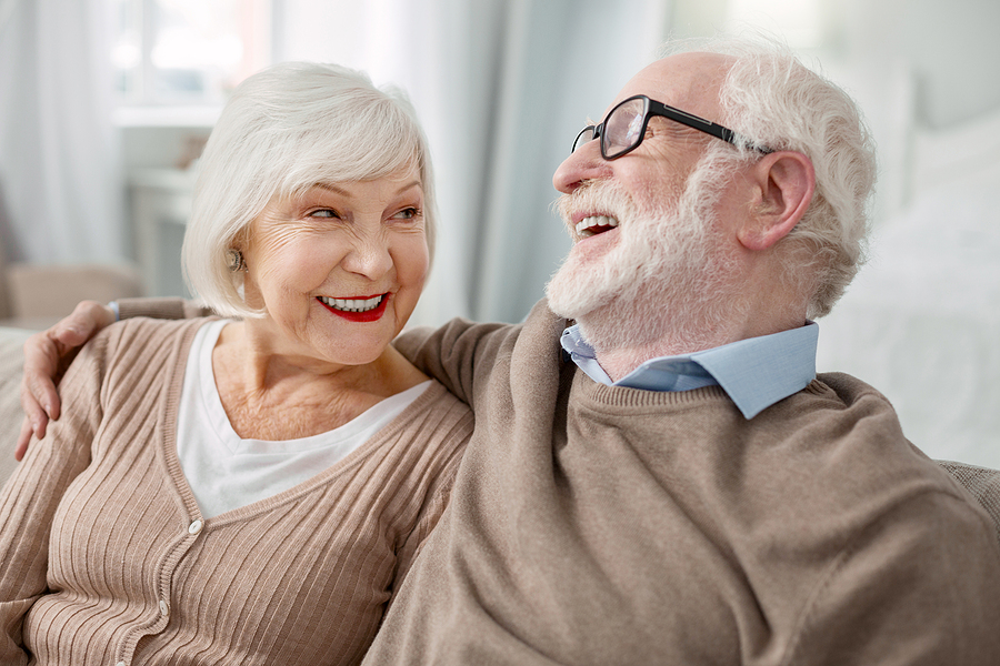 Two older adults happily discussing senior living locations.