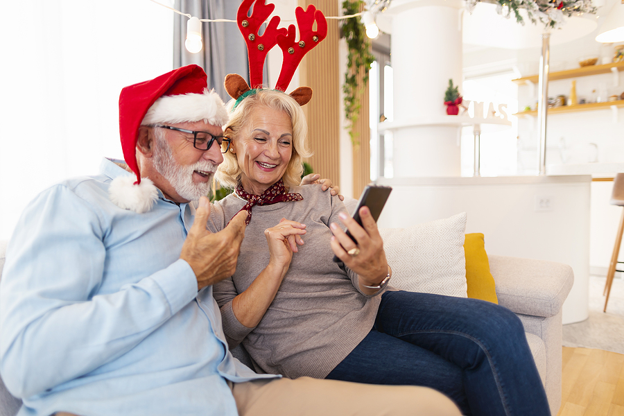 A senior couple does holiday trivia together on the couch