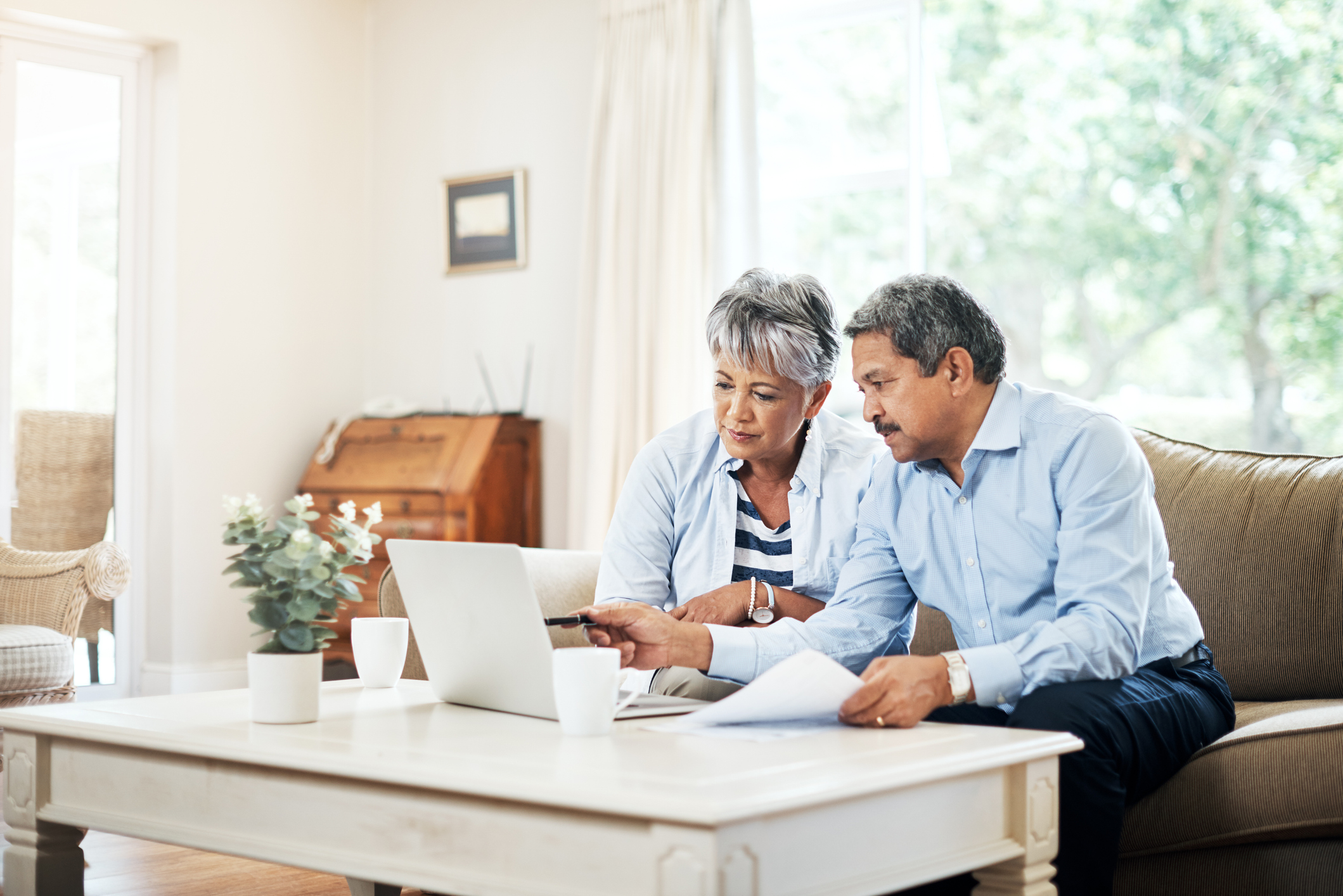 Older couple sitting on a couch and researching life care